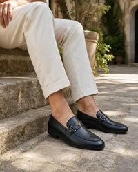 Man wearing black bit with linen trousers