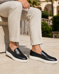 Man wearing black penny with linen trousers