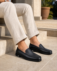 Man wearing black slip on with linen trousers