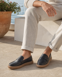 Man wearing black slip on with linen trousers