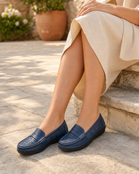Woman wearing navy flat with a cream midi skirt